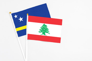 Lebanon and Curacao stick flags on white background. High quality fabric, miniature national flag. Peaceful global concept.White floor for copy space.