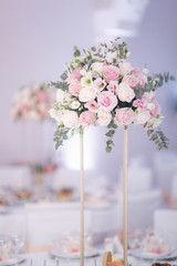 Decorated table for wedding celebration. Bright restaurand with a lot of windows. Flowers on the table