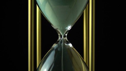 Hourglass clock time concept. Old vintage gold metal frame green sand clock countdown on dark...