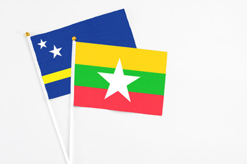 Myanmar and Curacao stick flags on white background. High quality fabric, miniature national flag. Peaceful global concept.White floor for copy space.