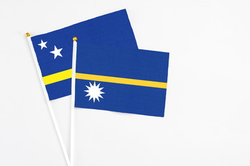 Nauru and Curacao stick flags on white background. High quality fabric, miniature national flag. Peaceful global concept.White floor for copy space.