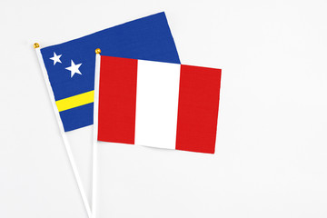 Peru and Curacao stick flags on white background. High quality fabric, miniature national flag. Peaceful global concept.White floor for copy space.