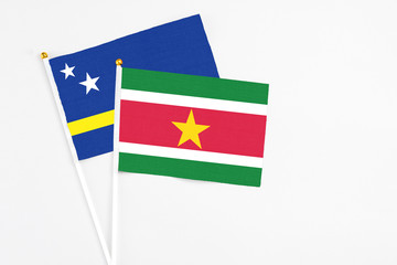 Suriname and Curacao stick flags on white background. High quality fabric, miniature national flag. Peaceful global concept.White floor for copy space.