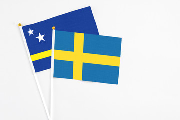 Sweden and Curacao stick flags on white background. High quality fabric, miniature national flag. Peaceful global concept.White floor for copy space.