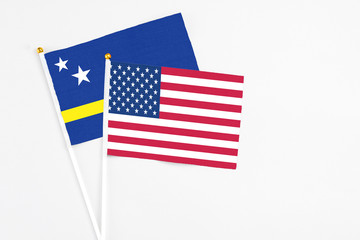 United States and Curacao stick flags on white background. High quality fabric, miniature national flag. Peaceful global concept.White floor for copy space.