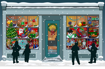 Storefront Christmas window filled with vintage toys, presents and colorful decorations. Silhouettes of children are outside, looking into the windows while snowflakes fall to the snowy sidewalk. 