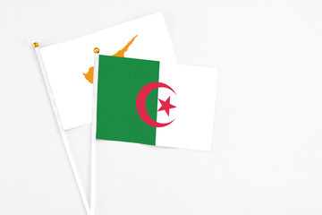 Algeria and Cyprus stick flags on white background. High quality fabric, miniature national flag. Peaceful global concept.White floor for copy space.