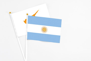 Argentina and Cyprus stick flags on white background. High quality fabric, miniature national flag. Peaceful global concept.White floor for copy space.