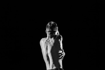 Black and white photograph of the back of a male artists performing an artistic show in the...