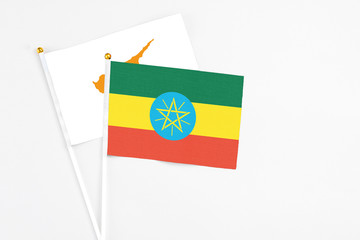 Ethiopia and Cyprus stick flags on white background. High quality fabric, miniature national flag. Peaceful global concept.White floor for copy space.