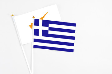 Greece and Cyprus stick flags on white background. High quality fabric, miniature national flag. Peaceful global concept.White floor for copy space.