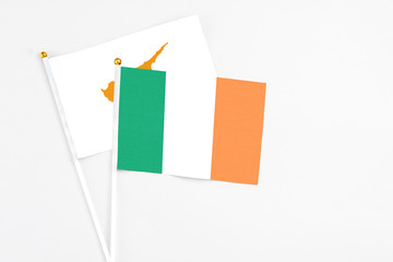Ireland and Cyprus stick flags on white background. High quality fabric, miniature national flag. Peaceful global concept.White floor for copy space.