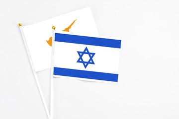 Israel and Cyprus stick flags on white background. High quality fabric, miniature national flag. Peaceful global concept.White floor for copy space.