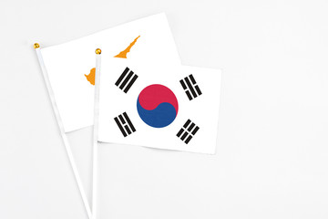 South Korea and Cyprus stick flags on white background. High quality fabric, miniature national flag. Peaceful global concept.White floor for copy space.