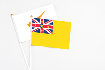 Niue and Cyprus stick flags on white background. High quality fabric, miniature national flag. Peaceful global concept.White floor for copy space.