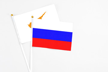 Russia and Cyprus stick flags on white background. High quality fabric, miniature national flag. Peaceful global concept.White floor for copy space.Russia