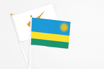 Rwanda and Cyprus stick flags on white background. High quality fabric, miniature national flag. Peaceful global concept.White floor for copy space.Rwanda