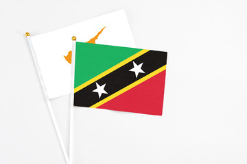 Obraz premium Saint Kitts And Nevis and Cyprus stick flags on white background. High quality fabric, miniature national flag. Peaceful global concept.White floor for copy space.