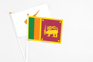 Sri Lanka and Cyprus stick flags on white background. High quality fabric, miniature national flag. Peaceful global concept.White floor for copy space.
