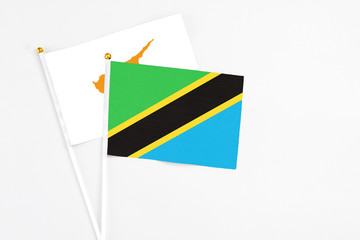 Tanzania and Cyprus stick flags on white background. High quality fabric, miniature national flag. Peaceful global concept.White floor for copy space.