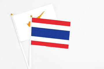 Thailand and Cyprus stick flags on white background. High quality fabric, miniature national flag. Peaceful global concept.White floor for copy space.