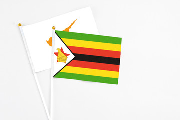 Zimbabwe and Cyprus stick flags on white background. High quality fabric, miniature national flag. Peaceful global concept.White floor for copy space.