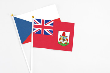 Bermuda and Cyprus stick flags on white background. High quality fabric, miniature national flag. Peaceful global concept.White floor for copy space.