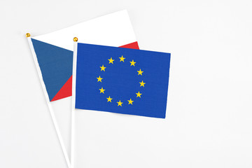 European Union and Cyprus stick flags on white background. High quality fabric, miniature national flag. Peaceful global concept.White floor for copy space.
