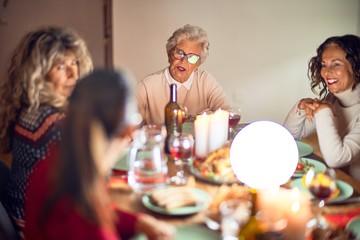 Beautiful group of women smiling happy and confident. Eating roasted turkey celebrating thanksgiving day at home