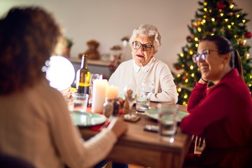 Beautiful group of women smiling happy and confident. Eating roasted turkey celebrating christmas at home