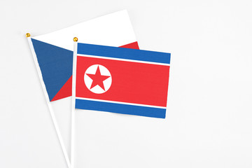 North Korea and Cyprus stick flags on white background. High quality fabric, miniature national flag. Peaceful global concept.White floor for copy space.