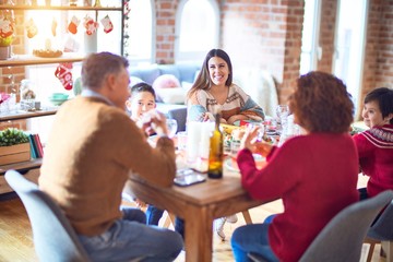 Beautiful family smiling happy and confident. Eating roasted turkey celebrating christmas at home