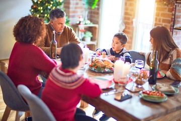 Beautiful family smiling happy and confident. Eating roasted turkey celebrating christmas at home