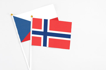 Obraz premium Norway and Cyprus stick flags on white background. High quality fabric, miniature national flag. Peaceful global concept.White floor for copy space.