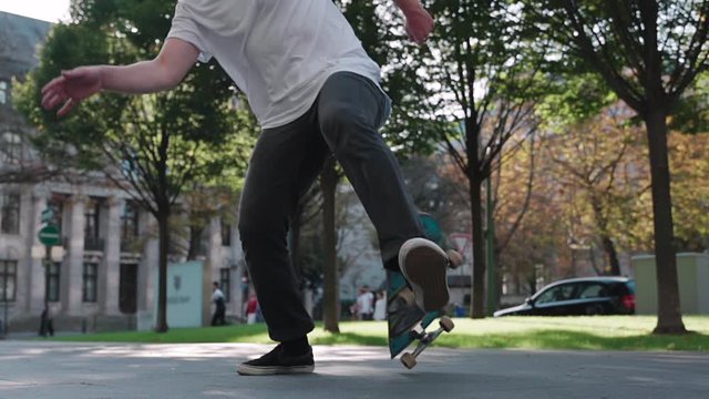 skateboarder fails doing flip trick in super slow motion at downtown city reflecting sun
