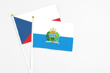 San Marino and Cyprus stick flags on white background. High quality fabric, miniature national flag. Peaceful global concept.White floor for copy space.