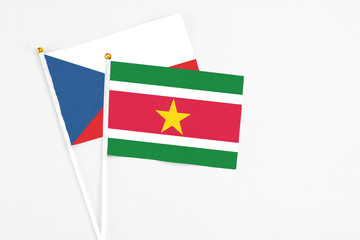 Suriname and Cyprus stick flags on white background. High quality fabric, miniature national flag. Peaceful global concept.White floor for copy space.
