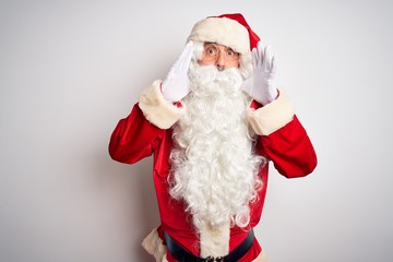 Middle age handsome man wearing Santa costume standing over isolated white background Shouting angry out loud with hands over mouth