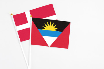 Antigua and Barbuda and Denmark stick flags on white background. High quality fabric, miniature national flag. Peaceful global concept.White floor for copy space.