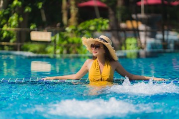 Naklejka premium Portrait beautiful young asian woman leisure relax smile and happy around swimming pool in hotel resort