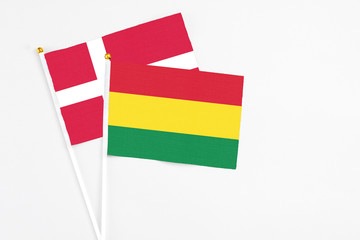 Bolivia and Denmark stick flags on white background. High quality fabric, miniature national flag. Peaceful global concept.White floor for copy space.