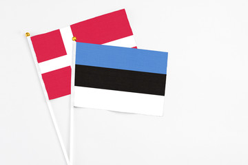 Estonia and Denmark stick flags on white background. High quality fabric, miniature national flag. Peaceful global concept.White floor for copy space.