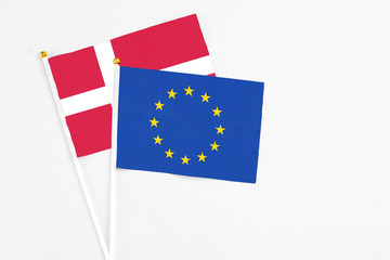 European Union and Denmark stick flags on white background. High quality fabric, miniature national flag. Peaceful global concept.White floor for copy space.