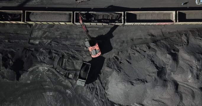 View from above. Coal port. The excavator is engaged in loading coal into railway cars.