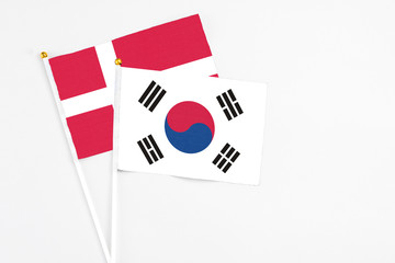 South Korea and Denmark stick flags on white background. High quality fabric, miniature national flag. Peaceful global concept.White floor for copy space.