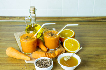 Fresh carrot juice in glass cups. Cocktail of carrot and orange juice with flax seeds.