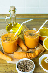 Fresh carrot juice in glass cups. Cocktail of carrot and orange juice with flax seeds.