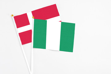 Nigeria and Denmark stick flags on white background. High quality fabric, miniature national flag. Peaceful global concept.White floor for copy space.