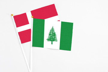 Norfolk Island and Denmark stick flags on white background. High quality fabric, miniature national flag. Peaceful global concept.White floor for copy space.