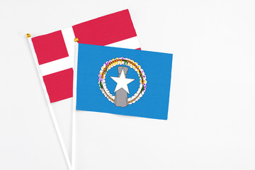 Northern Mariana Islands and Denmark stick flags on white background. High quality fabric, miniature national flag. Peaceful global concept.White floor for copy space.
